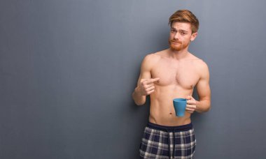 Genç, üstsüz, kızıl saçlı adam gelmek istiyor. Elinde bir kahve fincanı var..