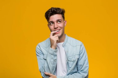 Kot gömlek giyen genç yakışıklı öğrenci rahatlamış fotokopi odasına bakan bir şey düşünüyor..