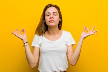Young natural caucasian woman relaxes after hard working day, she is performing yoga.
