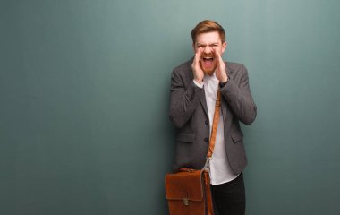 Genç kızıl saçlı işadamı bağırıyor, mutlu bir şeyler söylüyor.