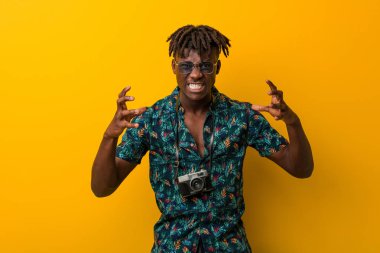 Tatil giymiş genç siyah Rasta adam gergin ellerle çığlık atıyor gibi görünüyor..