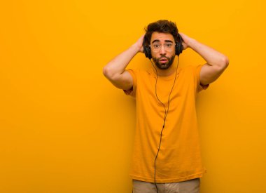 Müzik dinleyen genç adam endişeli ve bunalmış.