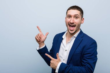 Genç beyaz bir adam işaret parmaklarıyla fotokopi alanını işaret ederek heyecan ve arzusunu ifade ediyor..