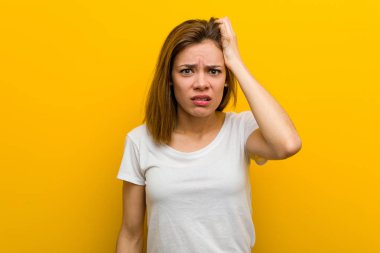 Young natural caucasian woman tired and very sleepy keeping her hand on her head.