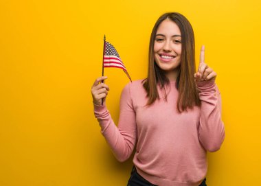 Amerika Birleşik Devletleri bayrağını tutan genç ve güzel bir kadın.