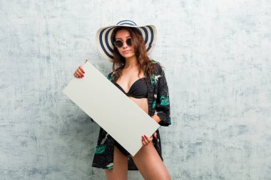Bikini giyen ve pankart tutan Avrupalı genç bir kadın.