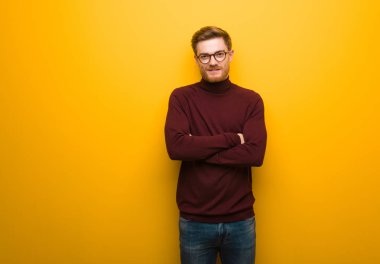 Genç akıllı adam kollarını kavuşturuyor, gülümsüyor ve rahatlıyor.