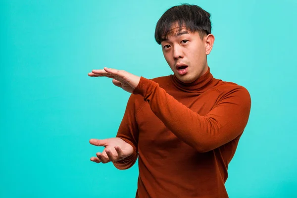 Young Chinese Man Holding Something Very Surprised Shocked — Stock Photo, Image