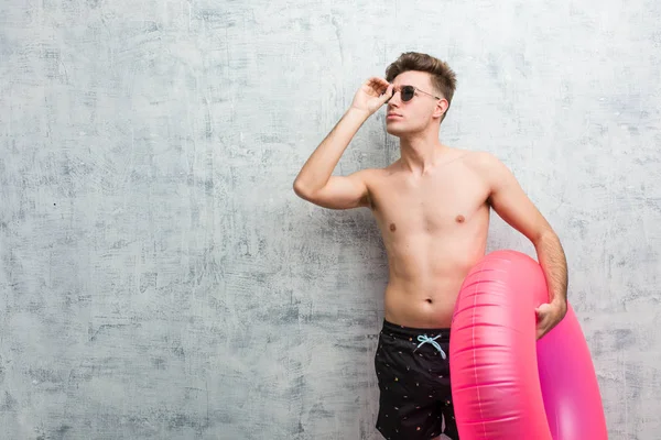 Junger Mann Mit Einem Rosafarbenen Aufblasbaren Donut Einem Badeanzug Der — Stockfoto