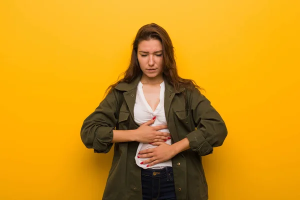 黄色の背景の病気で孤立した若いヨーロッパの女性 腹痛に苦しんで 痛みを伴う病気の概念 — ストック写真