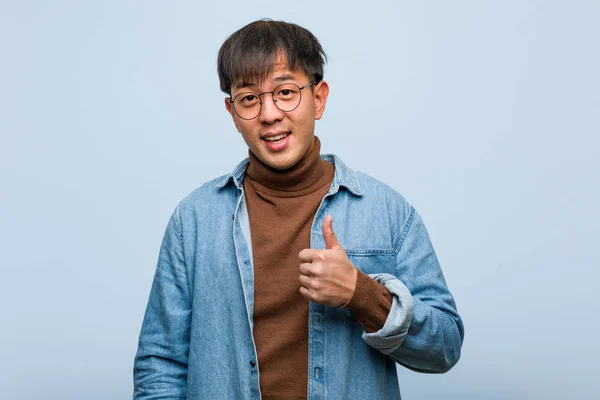 年轻的中国男子微笑着竖起大拇指 — 图库照片