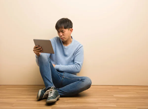 Jovem Chinês Sentado Usando Seu Tablet Cruzando Braços Relaxado — Fotografia de Stock