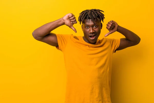 Joven Hombre Negro Vistiendo Rastas Sobre Fondo Amarillo Mostrando Pulgar —  Fotos de Stock