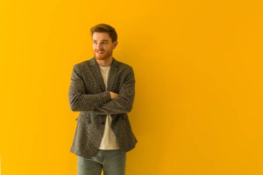 Genç kızıl saçlı iş adamı kendine güvenen ve kollarını kavuşturup yukarı bakıyor.