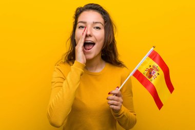 Genç Avrupalı kadın elinde İspanyol bayrağıyla heyecanla bağırıyor..