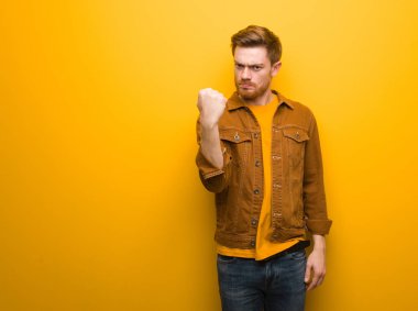 Genç Kızıl saçlı adam gösteren yumruk öne, kızgın ifade