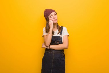 Genç hippi kadın bir şeyler düşünüyor, yana bakıyor.