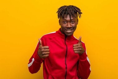 Genç fitness siyah adam iki parmağını kaldırıyor, gülümsüyor ve kendinden emin..