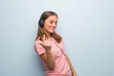 Genç, güzel, beyaz bir kadın davet ediyor. Kulaklıkla müzik dinliyor..