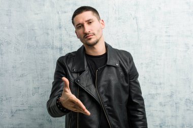 Genç rockçı elini kameraya uzatarak selam veriyor..