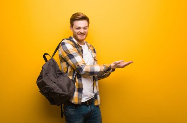 Genç kızıl saçlı öğrenci elleriyle bir şey tutuyor.