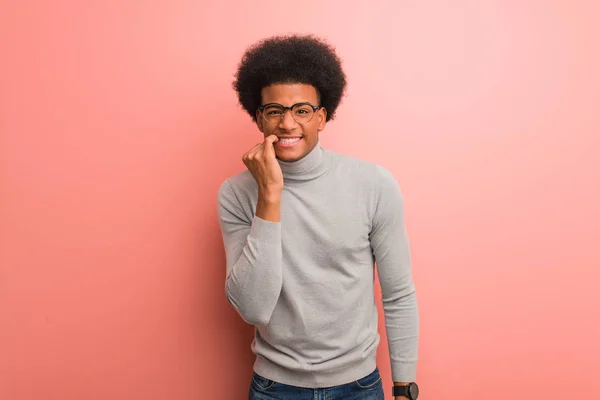 年轻的非洲裔美国人在粉红色的墙壁咬指甲 紧张和非常焦虑 — 图库照片