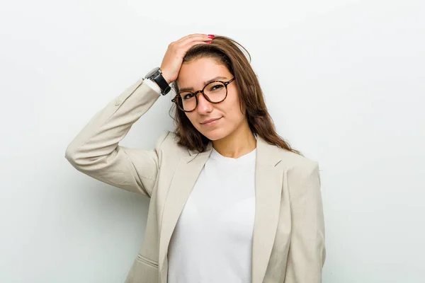 Young european business woman forgetting something, slapping forehead with palm and closing eyes.