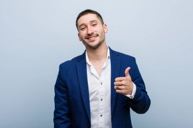 Genç beyaz adam gülümsüyor ve başparmağını kaldırıyor.