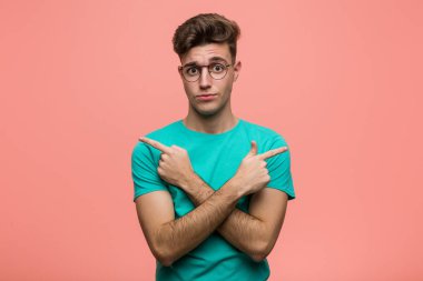 Genç havalı beyaz adam iki seçenek arasında seçim yapmaya çalışıyor..