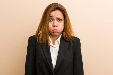 Kafkasyalı genç iş kadını yanakları siliyor, yorgun bir ifadesi var. Yüz ifadesi kavramı.