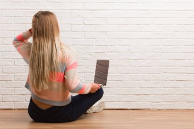 Arkadan oturan genç Rus öğrenci bir şey düşünüyor.