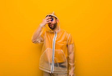 Yağmurluk giyen genç adam aynı anda hem utanmış hem de gülüyordu.