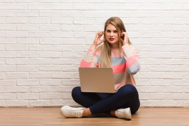 Genç Rus öğrenci kadın elleriyle kulaklarını kapatıyor.