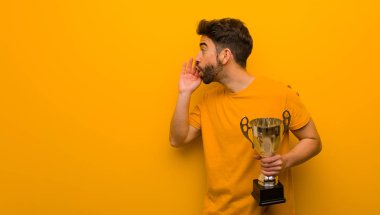 Elinde kupa tutan genç adam fısıldayarak dedikodu yapıyor.