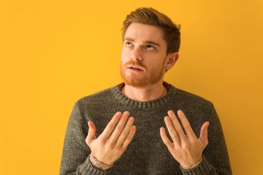 Genç kızıl saçlı adamın yüzü, yorgun ve sıkılmış.