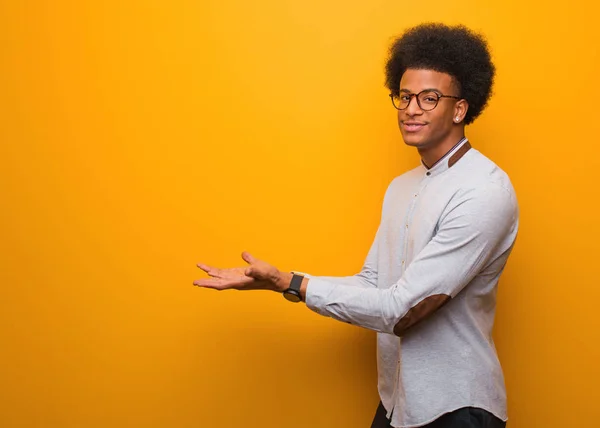 Giovane Uomo Afroamericano Sopra Muro Arancione Che Tiene Qualcosa Con — Foto Stock