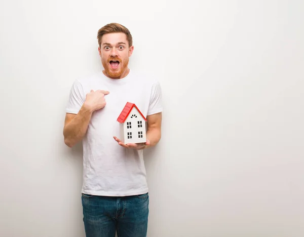 Young Redhead Man Surprised Feels Successful Prosperous Holding House Model — Stock Photo, Image