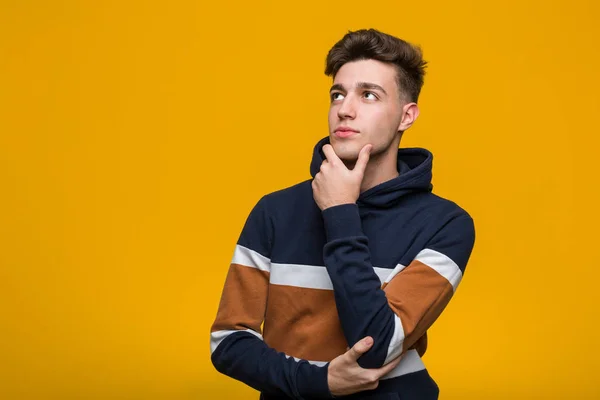 Jonge Coole Man Draagt Een Hoodie Kijken Zijwaarts Met Twijfelachtige — Stockfoto