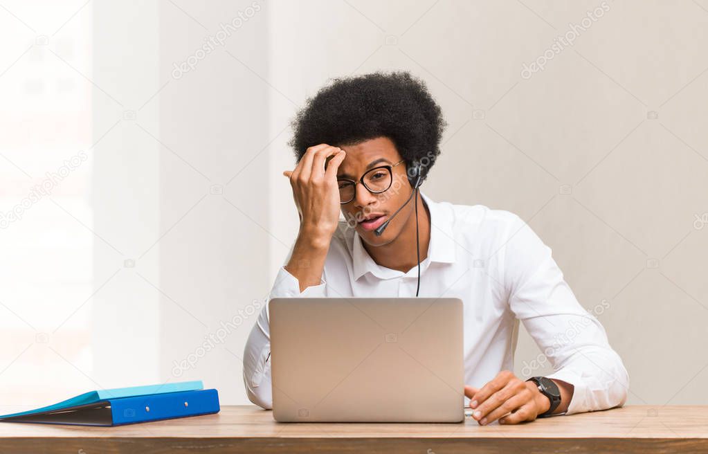 Young telemarketer black man worried and overwhelmed