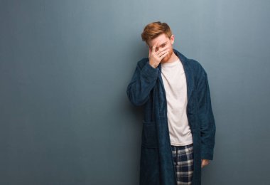 Pijamalı genç kızıl adam aynı anda hem utanmış hem de gülüyordu.