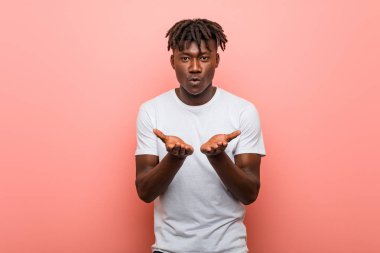 Genç Afrikalı siyah adam dudaklarını katlıyor ve hava öpücüğü vermek için avuç içi tutuyor..