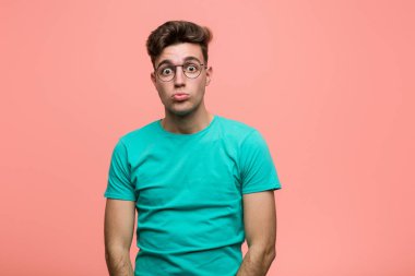 Genç, havalı, beyaz bir adam omuzlarını silker ve kafası karışır..