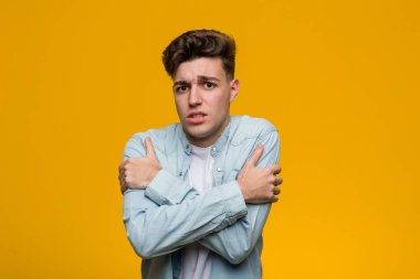 Kot gömlek giyen genç yakışıklı bir öğrenci düşük ateş ya da hastalık yüzünden soğuyor..