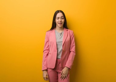 Genç, modern iş kadını göz kırpıyor, komik, arkadaşça ve kaygısız bir jest yapıyor.