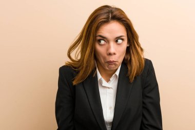 Kafkasyalı genç iş kadını omuz silker ve kafası karışır..