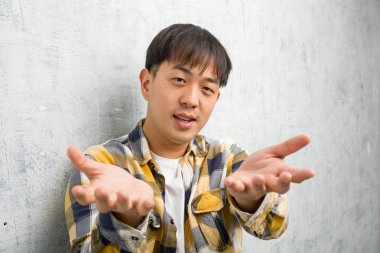 Genç Çinli adam yakından davet edilmeyi bekliyor.