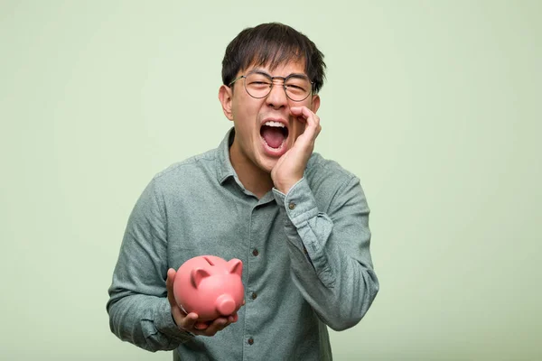 Jovem Asiático Homem Segurando Porquinho Banco Gritando Algo Feliz Para — Fotografia de Stock