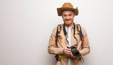 Genç kızıl saçlı kaşif, neşeli ve büyük bir gülümsemesi var. Bir kamera tutuyorum..