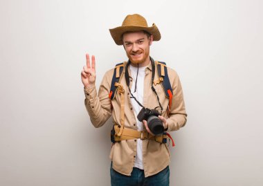 Genç kızıl saçlı kaşif iki numarayı gösteriyor. Bir kamera tutuyorum..