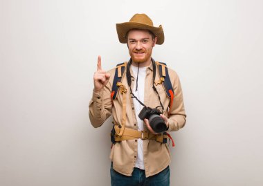 Genç kızıl saçlı kaşif bir numara gösteriyor. Bir kamera tutuyorum..